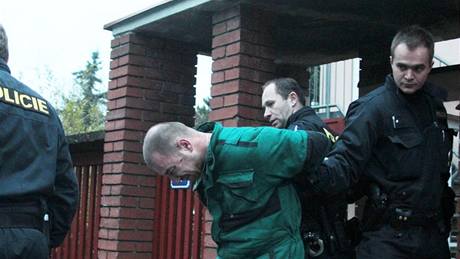 Policisté odvádjí mue, který na praské Bertramce útoil na pivolanou hlídku (23.11. 2010)