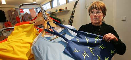 Alena Samková z galerie ukazuje textilie s motivy íslice 5. Na váku visí trika, která jsou k dispozici zájemcm pro naehlení .