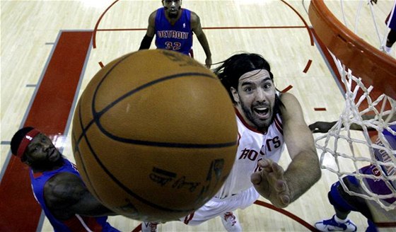 Nezadritelný Luis Scola z Houstonu dává ko  , vlevo pihlíí Ben Wallace z Detroitu.