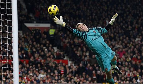 Gólman Wojciech Szczesny z Arsenalu se marn natahuje po stele  Park i-songa z Manchesteru United. 