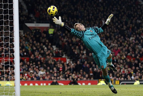 Gólman Wojciech Szczesny z Arsenalu se marn natahuje po stele  Park i-songa z Manchesteru United. 