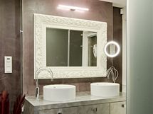 Hlavní dominantu koupelny tvoří pult s umyvadly ve stříbrné fólii s vestavnými zásuvkami pod deskou