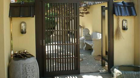 Devná vstupní brána pochází z Japonska. Ped branou jsou po obou stranách nezbytné oistné studánky