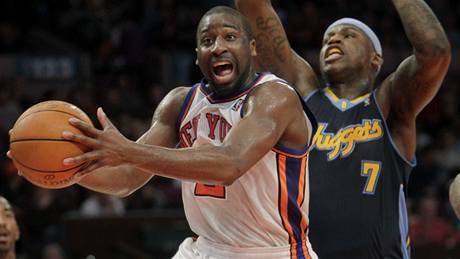 Raymond Felton z New Yorku Knicks (vlevo) se prosazuje pes Ala Harringtona z Denveru.  