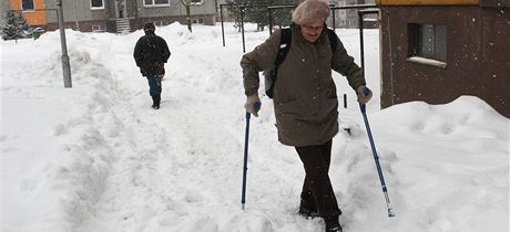 Na sídlišti Dobiášova v Liberci chodí lidé místo po chodníku hlubokým sněhem.