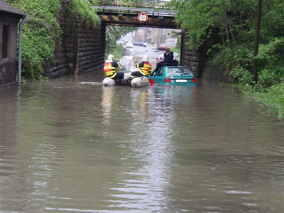 Hasiči zachraňují řidiče, který s vozem uvázl při povodni v Bohumíně.