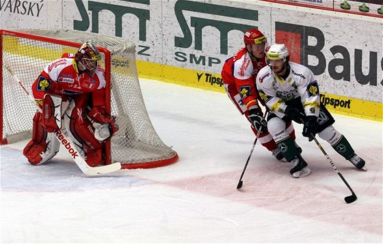 Utkání 38. kola hokejové extraligy Karlovy Vary - eské Budjovice: eskobudjovický branká Jakub Ková (vlevo), jeho spoluhrá Michael Kolarz a karlovarský Martin Zaovi (vpravo).