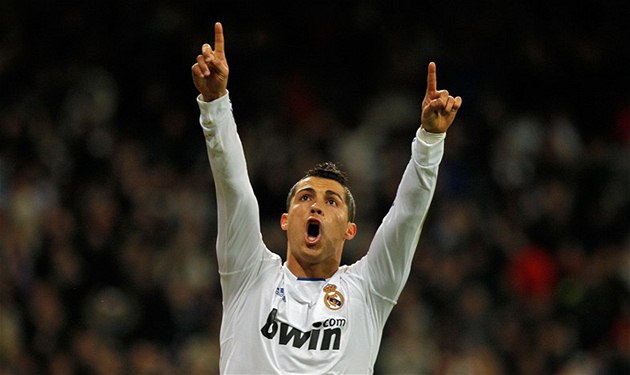 футболист поднимает руки к небу после гола