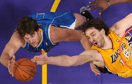 Aaron Gray (vlevo) z New Orleans Hornets doskakuje m v souboji s Pauem Gasolem z LA Lakers.