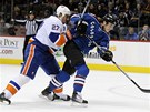 Hokejista Colorada Avalanche Ryan O'Reilly stílí, i kdy na nj zezadu tlaí slovenský bek Milan Jurina z New York Islanders. 
