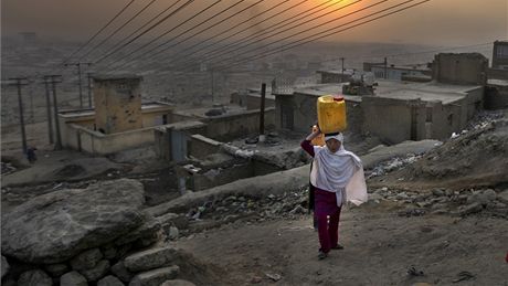 Afghánská dívka nese kanystr s vodou v Kábulu