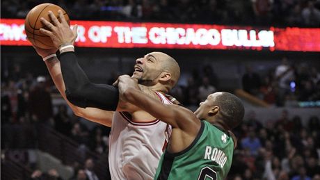 Carlos Boozer  z Chicaga zakonuje, fauluje ho Rajon Rondo z Bostonu.