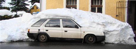 Padající sníh ze střechy zasypal dvě auta.