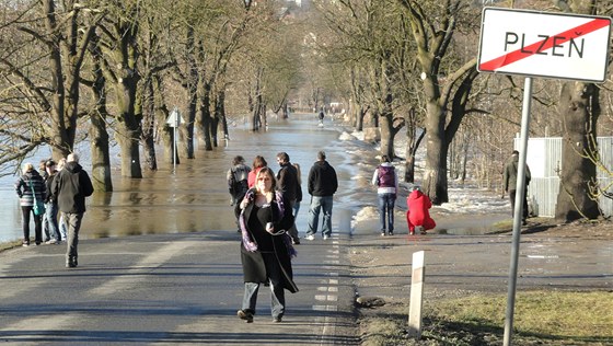 Lidé si fotografují zatopenou silnici u Kalikovského mlýna v Plzni