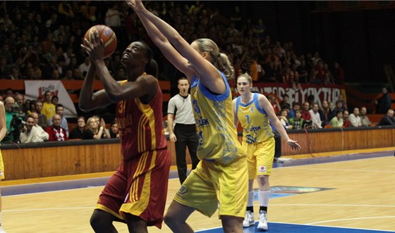 Sylvia Fowlesová (v erveném) z Galatasaray Istanbul zakonuje pes obranu Petry Kulichové z USK Praha.