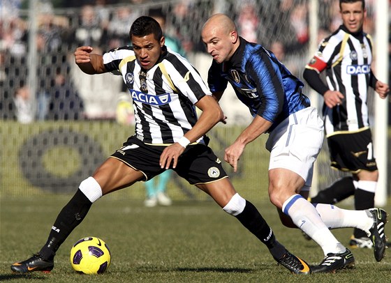 KRYTÍ MÍE. Alexis Sanchez z Udinese (v ernobílém dresu) si kryje mí ped Estebanem Cambiassem z Interu Milán.