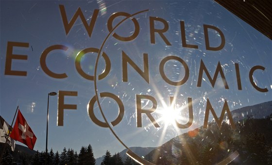 Paprsky slunce pronikají logem světového ekonomického fóra ve švýcarském Davosu...
