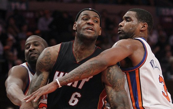 LeBron James (uprosted) z Miami Heat pod tlakem Raymonda Feltona (vlevo) a Shawna Williamse z NY Knicks.