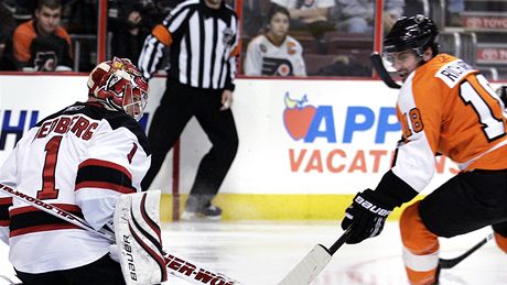 védský branká Johan Edberg ve slubách New Jersey Devils kryje stelu Mike Richards z Philadelphie Flyers. 