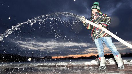 Jan Urbánek mladí pomáhá kropit. Ze zamrzlé vody vznikne bruslaská dráha.