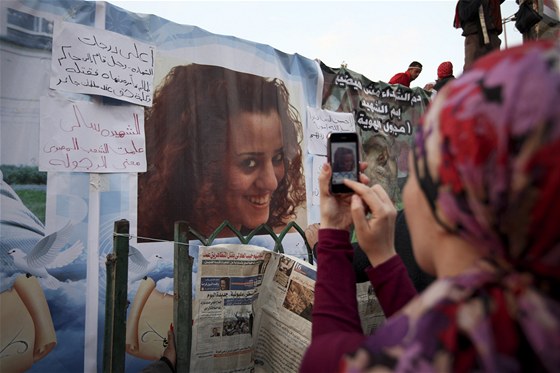 Egypané si prohlíejí portréty zabitých demonstrant na káhirském námstí Tahrír (9. února 2011)