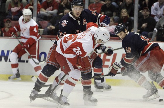 V PEDKLONU. eský hokejista Jií Hudler z Detroitu (. 26) se ohlíí po puku, ale nedostane se k nmu. Soupe Ryan Callahan v dresu Rangers má dobrou pozici, aby jej od kotoue odtlail.