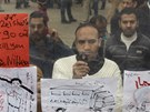 Demonstranti na káhirském námstí Tahrír si prohlíejí nástnku s protireimními slogany (8. února 2011)