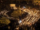 Egypané na káhirském námstí Tahrír krouí se svíkami v ruce kolem tanku (9. února 2011)