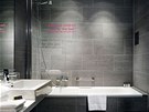 Elegantní koupelnu v edé barv oivuje úryvek textu Petra Síse