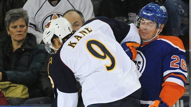 SOUBOJ U MANTINELU. Evander Kane z Atlanty bojuje o puk s Kurtisem Fosterem z Edmontonu v zápase NHL.