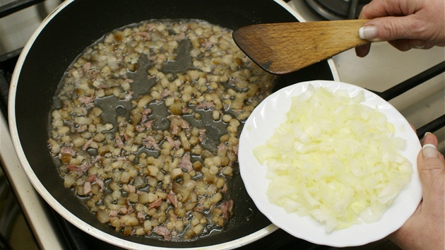Na pánvi orestujte nadrobno pokrájený špek, přidejte nasekaný česnek a po chvilce přisypte i pokrájenou cibuli