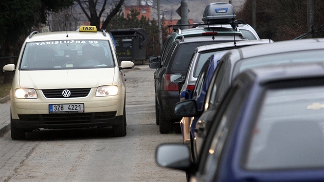 Okruní ulice ve Zlín ucpaná zaparkovanými automobily.