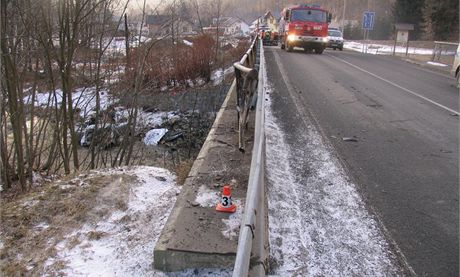 Svodidla a zbradl mostu v Koutech nad Desnou, u kterho idi BMW kvli vysok rychlosti dostal smyk a vz nsledn peletl pes svodidla a skonil v ece.