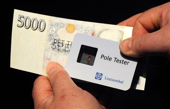 len bankovní rady NB Pavel eábek pedvádí tzv. pole tester (pomcku na provování ochranných znak bankovek). (28. února 2011)