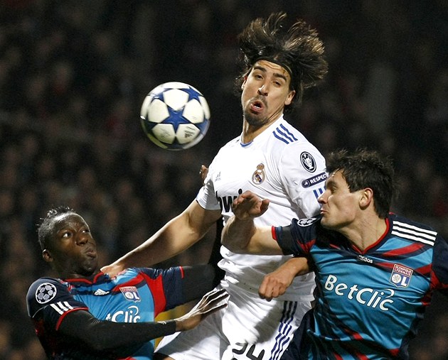 V KLIN�I. Sami Khedira z Realu Madrid se mezi dv�ma hrá�i Lyonu sna�í vybojovat mí�.
