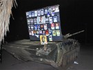 Tablo s portréty Libyjc zabitých Káaddáfího jednotkami na oputném tanku v Benghází (22. února 2011)
