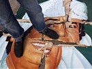 Libyjec stojí na znieném portrétu Muammara Kaddáfího (24. února 2011)