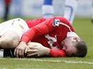 JAU. Wayne Rooney  z Manchesteru United trpí po jednom ze zákrok soupee pi utkání s Wiganem.