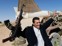 Libyjec s kalanikovem se v oputn vojensk zkladn raduje ze zskan kontroly nad Tobrukem. (23. nora 2011)