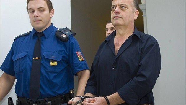 Eskorta p�ivádí ke krajskému soudu v plzni Antonína Wertheima, za podíl na vra�d� nepohodného sv�dka dostal 14 let
