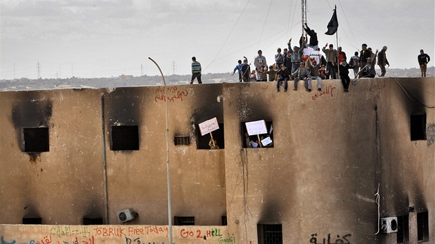 Libyjtí demonstranti stojí na stee vypálené policejní stanice v Tobruku. (23. února 2011)