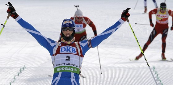 Martin Fourcade se raduje ze zlaté medaile ze stíhacího závodu na MS. Za ním finiují stíbrný Svendsen (vlevo) a Bö