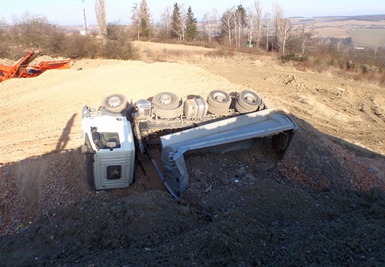 Nákladní auto se pevrátilo na bok pi vysypávání pimrzlé suti.