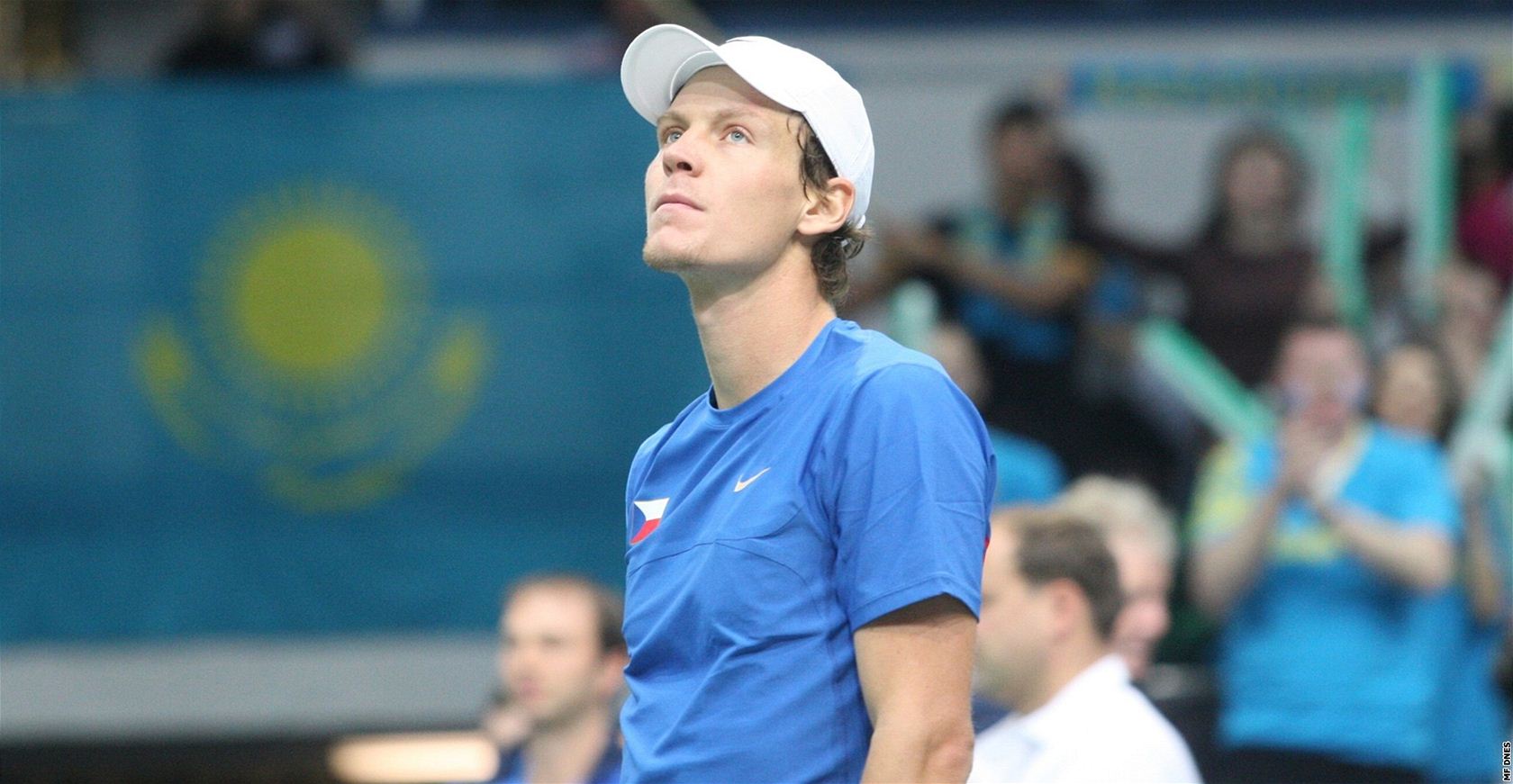 ZKLAMANÝ FAVORIT. Tenista Tomá� Berdych po proh�e v  Davis Cupu smutn� sleduje rozradostn�né kaza�ské fanou�ky.