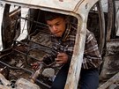Libyjský chlapec si hraje ve vyhoelém vraku auta v Tobúku. (3. bezna 2011)