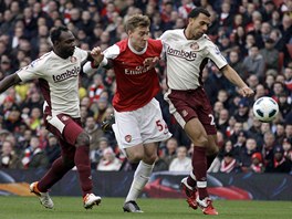 PROJDU? Nicklas Bendtner z Arsenalu se probj pes Johna Mensaha a Antona Ferdinanda ze Sunderlandu.