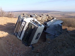 Nkladn auto se pevrtilo na bok pi vysypvn pimrzl suti.