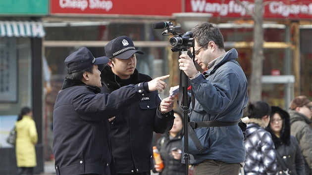 Policisté vykazují kameramana AP z obchodní tídy v centru Pekingu