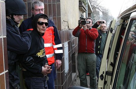 Policie odvádí agresivního mue z rokycanského domu, kde vtrhl do cizího bytu a zabarikádoval se v nm 