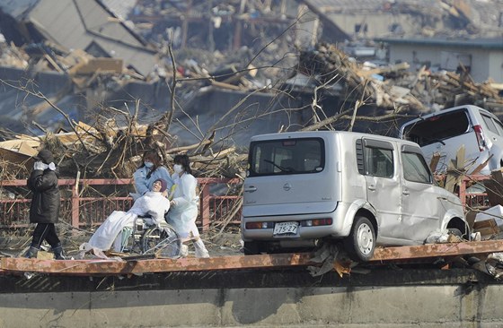 Japonci evakuují pacientku nemonice v Otsuchi. (13. bezna 2011)